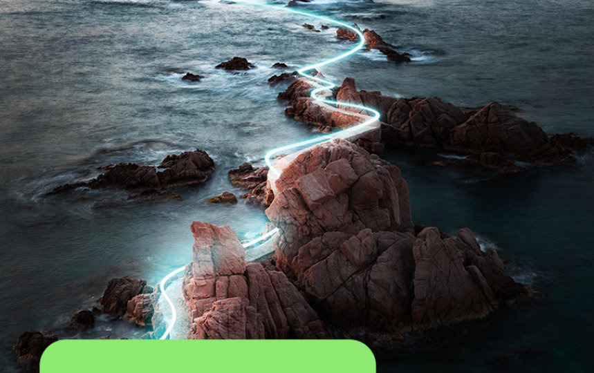 A glowing light trail winds across rocks in the ocean.