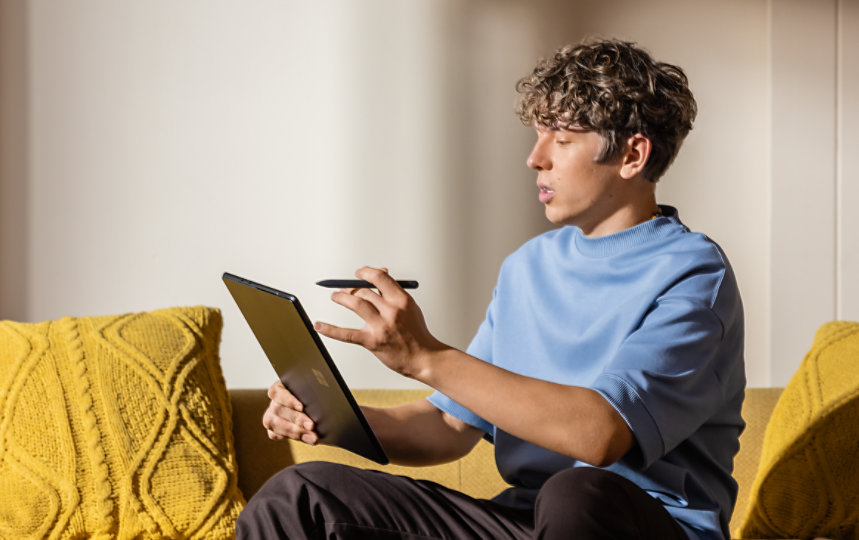 A student does his homework with a black Surface Pro, and Surface Slim Pen.