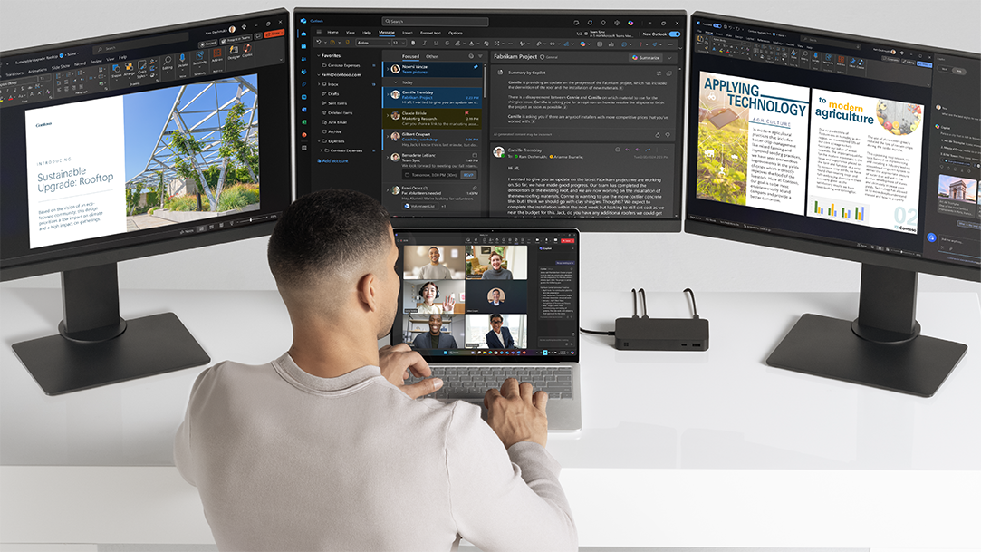 Image of a man collaborating on a Surface Laptop Copilot+ PC on a Teams call with 3 monitors