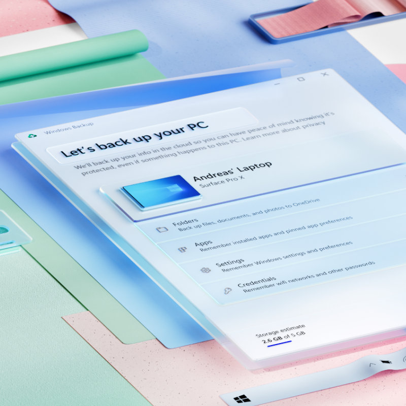 Widok aplikacji Kopia zapasowa systemu Windows, przedstawiający opcje wykonania kopii zapasowej komputera osobistego, zaś za aplikacją widać warstwy arkuszy jasnego papieru